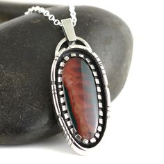 A beautiful Idaho Sunset Jasper Agate stone set in a Sterling Silver Necklace. This stunning jasper agate is a new and rare material mined in central Idaho with the most amazing color patterns. This stone loves being in the sunlight where the colors really pop and stand out the best. The colors can appear darker in shadier conditions. Pendant measures 2.5cm wide by 6.4cm long. Comes on an 18 inch sterling silver oval belcher chain. Includes gift box. Handmade by Annie Summers. We are husband and Artisan Jasper Jewelry Gift, Jasper Jewelry With Natural Stones For Gift, Multicolor Jasper Jewelry For Gift, Polished Multicolor Jewelry For Gift, Multicolor Polished Jewelry As A Gift, Multicolor Polished Jewelry As Gift, Multicolor Polished Jewelry For Gifts, Artisan Jasper Jewelry With Large Stone, Artisan Jasper Jewelry In Oval Shape