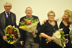 a group of people standing next to each other holding bouquets of flowers in their hands