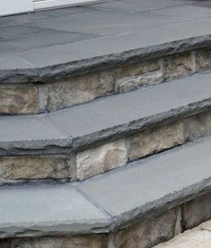 the steps are made out of stone and have been placed on each side of the door