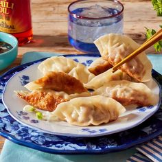 some dumplings are on a plate with chopsticks