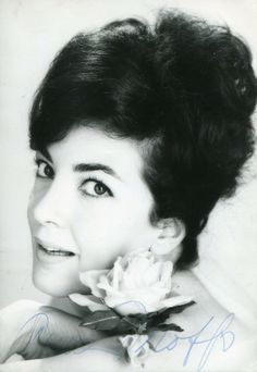 an old black and white photo of a woman with a flower in her hair