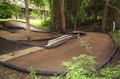 an outdoor play area in the woods with water hoses