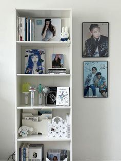 a white book shelf filled with books and pictures