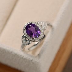 This ring features a 6*8mm oval cut natural amethyst and sterling silver finished with rhodium. Customization is available. It is made by hand, and it will take about 7 days to finish the ring after your payment is completed. Main stone: natural amethyst Amethyst weight: Approx 1.25 ct Metal type: sterling silver finished with rhodium Accent stone: cz Customization is available, I also can make it with 14k solid gold (white or yellow or rose) and diamond accent stone, just feel free to contact m Pretty Wedding Rings, Silver Halo Ring, Purple Amethyst Ring, Diamond Engagement Wedding Ring, Diamond Wedding Ring, Amethyst Ring, Birthstone Ring, Black Rings, Diamond Wedding Rings