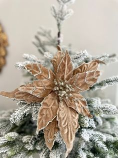 an ornament on top of a christmas tree with snow flakes and leaves