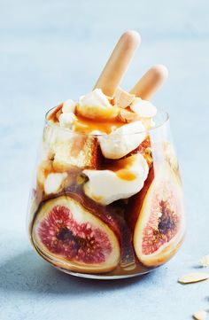 a dessert in a glass with fruit and marshmallows