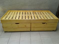 a wooden bed with two drawers on the bottom