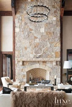 a living room filled with furniture and a stone fireplace