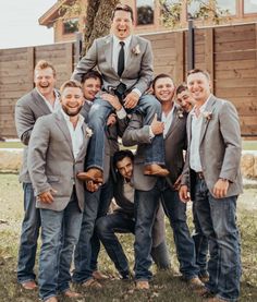 a group of men standing next to each other in front of a tree