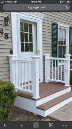 a white porch with green shutters next to a door and steps on the side of a house