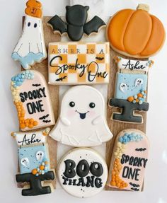 decorated cookies are arranged in the shape of ghostes and pumpkins on a board