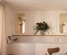 a dining room table and chairs in front of three mirrors