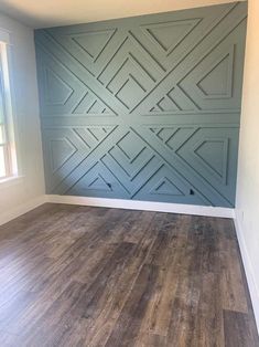 an empty room with wood flooring and blue painted panels on the side of the wall