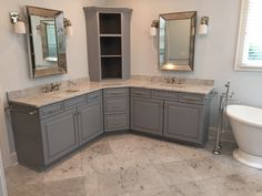 a bathroom with gray cabinets and marble counter tops