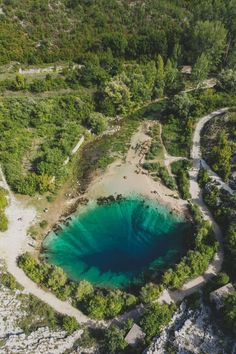 an aerial view of a blue lake surrounded by trees