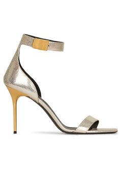 Crafted to a dramatic stiletto silhouette, these Uma sandals boast a lizard-skin effect and are completed in a gold-tone hue.Lizard-skin effectMetallic finishOpen toeSquare toeBuckle-fastening ankle strapHigh stiletto heel 4"Composition: Lambskin 100%Sole: Leather 100%Lining: Leather 100%Made in Italy Gold Sandals With Reinforced Heel For Evening, Modern Gold Sandals With Reinforced Heel, Luxury Metallic Sandals With 4-inch Heel, Luxury Metallic Pointed Toe Sandals, Luxury Metallic Sandals With Sculpted Heel, Chevron Outfit, Chevron Jewelry, White Sandals Heels, Shoes Flats Sandals