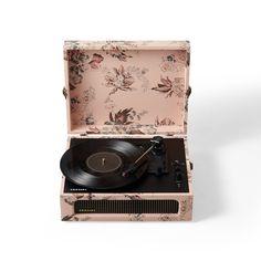 an open suitcase with a record player in it's lid and floral wallpaper