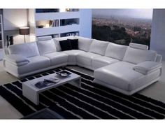 a white leather sectional sofa in a living room with black and white rug on the floor