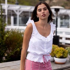 Sweet and simple cotton voile sleeveless blouse with our custom eyelet ruffle trim. Rosette at the neckline and red gingham ribbon tie at the waist. Buttons up the front. Scoop back with a tie at the top so the sleeves stay up. Emilia is wearing size S and has a 30.5" bust, 24" waist, 36" hips, and is 5'5" tall. Maile is wearing size XL and is 5'6" tall, with a 39" bust, 29" waist, and 38" hips. Andy is wearing size XS and has a 31.5" bust, 24" waist, 35" hips, and is 5'5" tall. Annika is wearin Red Gingham, Ribbon Tie, Stay Up, Cotton Voile, Sleeveless Blouse, Ruffle Trim, Gingham, Button Up, Ribbon