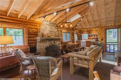 a living room filled with furniture and a fire place next to a window covered in wood