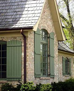 an old brick house with green shutters on the front and side windows in french country - shutters, overhang brackets, home ideas exterior storybook and classic shutters