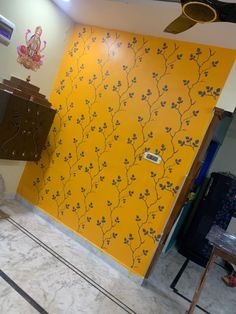 a room with yellow and black wallpaper on the walls next to a brown cabinet