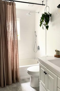 a bathroom with a toilet, sink and shower in it's center area next to a bathtub