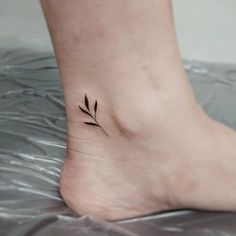 a small tattoo on the foot of a woman's left foot, with a single flower