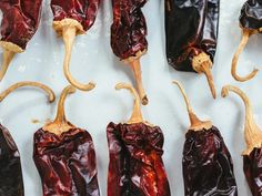 red peppers are lined up on a white surface