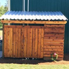 a wooden shed with a metal roof