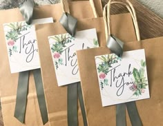 three brown paper bags with thank you tags attached to the handles and bows on them