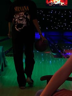 a man standing in front of a bowling ball