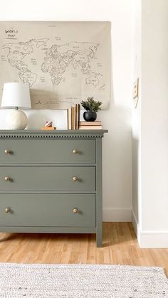 a dresser with drawers and a map on the wall