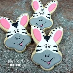 three decorated cookies with zebra faces on them