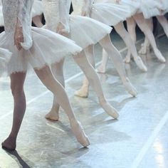 several ballerinas are lined up in white tutus