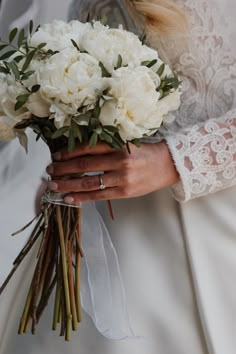 a bride holding a bouquet of white flowers