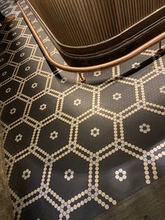 a black and white tiled floor next to a brown suitcase on top of a stand