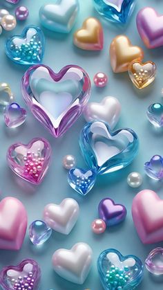 many different colored heart shaped candies on a light blue surface with pearls in the middle