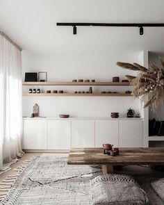 a living room filled with furniture and a large rug on top of a wooden floor