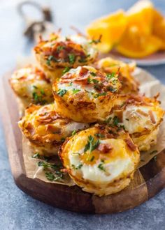 some food that is sitting on a wooden platter with oranges in the background