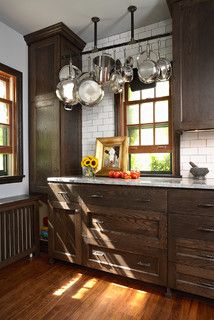 a kitchen with wooden cabinets and hanging lights