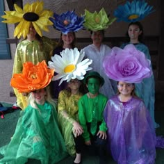 some people are dressed up and posing for a photo with flowers on their heads in front of them