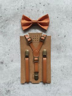 Sunset Orange burlap bow ties with matching faux leather center paired as a set with caramel brown faux leather suspenders. Sets include one suspender and one bow tie.  Suspenders are available in both skinny 1/2" and 1" width. A great match to our Sunset Orange silk neckties and pocket squares.  **Adult pocket square is sold separately.** Trust the designers at London Jae Apparel to have you looking dashing at your next event. No matter the occasion, our floral designs will have you standing ab Classic Brown Suit And Tie Accessories For Father's Day, Classic Brown Belts And Suspenders For Wedding, Classic Brown Bow Tie For Groom, Brown Bow Suit And Tie Accessories For Party, Brown Bow Tie For Wedding, Adjustable Brown Bow Tie For Party, Brown Bow Tie For Wedding And Father's Day, Father's Day Brown Formal Bow Tie, Adjustable Brown Bow Tie In Dapper Style