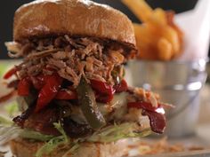 a pulled pork sandwich with peppers and onions