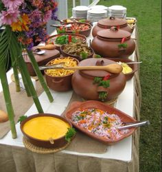 a table topped with lots of pots and pans filled with food on top of it