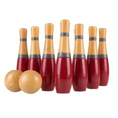 a group of red and yellow bowling pins next to an orange ball on a white background