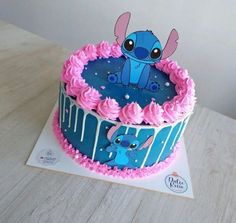 a blue and pink birthday cake with an image of stitcher on it