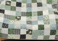 a green and white patchwork quilt sitting on top of a wooden chair