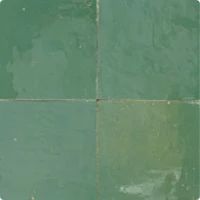 a green tiled floor with white grouting on the top and bottom tiles in different colors