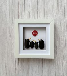 three black stones are in a white frame